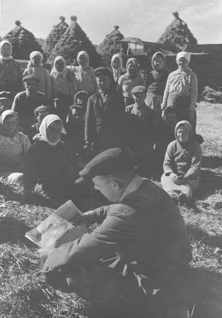 ГАПК. Фотофонд. П-826. Читка газеты во время обеденного перерыва в поле на молотьбе. За газетой – председатель сельсовета – Громовик, колхоз Активист, Анучинский район, 1950 г..jpg